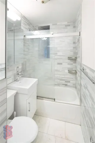 a bathroom with a sink mirror vanity and toilet