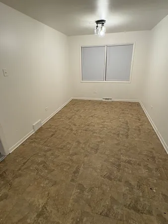an empty room with cabinet and windows