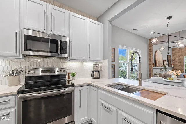 a kitchen with cabinets stainless steel appliances a sink and a microwave