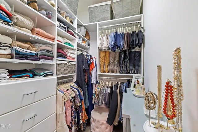 a view of walk in closet with clothes and shoes