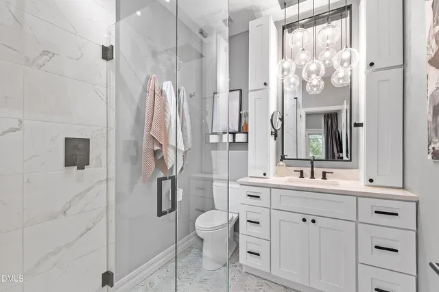 a bathroom with a double vanity sink mirror and toilet