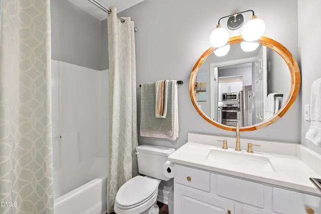 a bathroom with a sink a mirror a toilet and a mirror