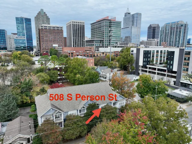a sign board with buildings in the background