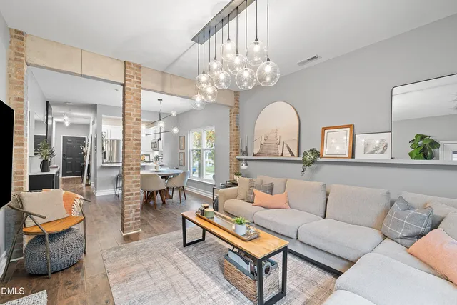 a living room with furniture a chandelier and a large mirror