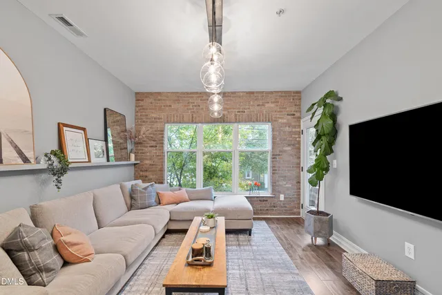 a living room with furniture a flat screen tv and a large window
