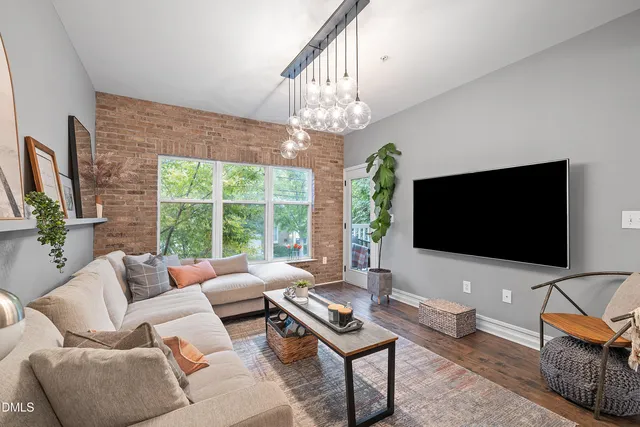 a living room with furniture a flat screen tv and a large window