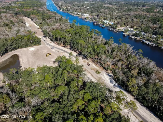 an aerial view of a house with a yard and lake view