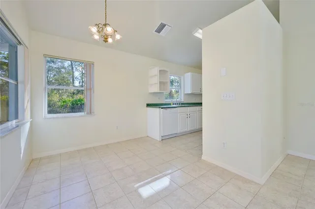 a kitchen with granite countertop a sink window and cabinets