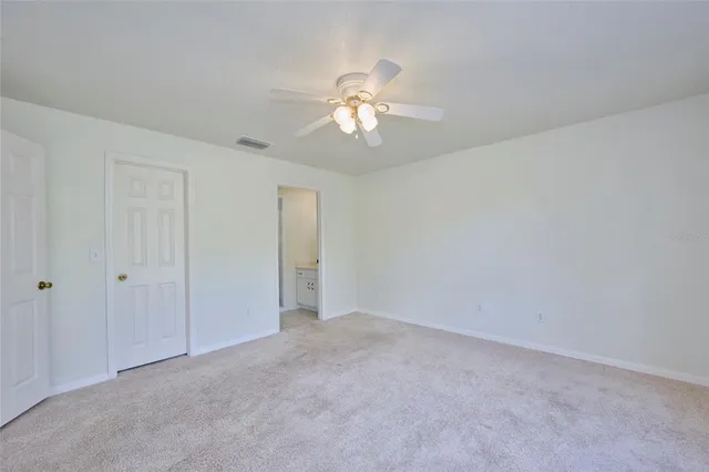 a view of a big room with windows and chandelier fan