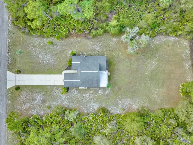 a front view of a house with a yard and potted plants