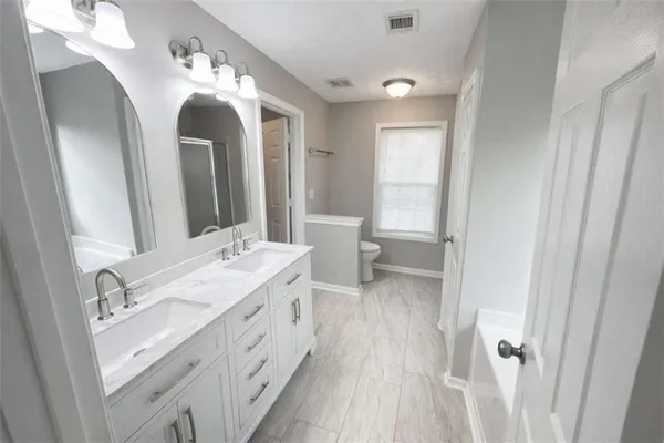 a spacious bathroom with a double vanity sink and a mirror