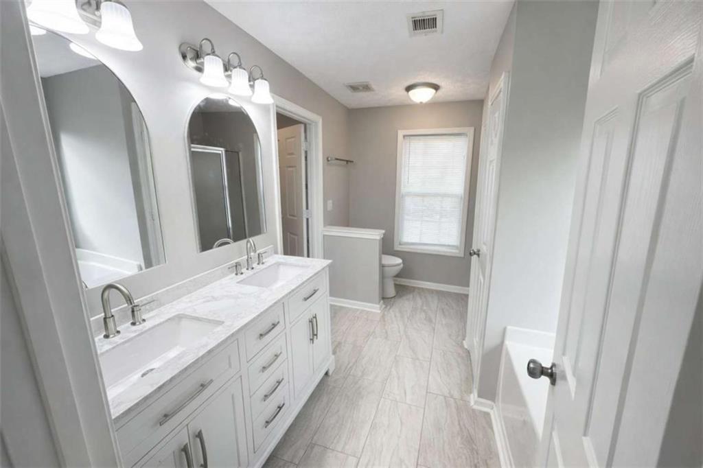 118 Chippewa Run Auburn, GA 30011 - Photo 11 of 26 a spacious bathroom with a double vanity sink and a mirror