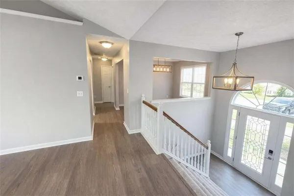 a view of a hallway with wooden floor and staircase