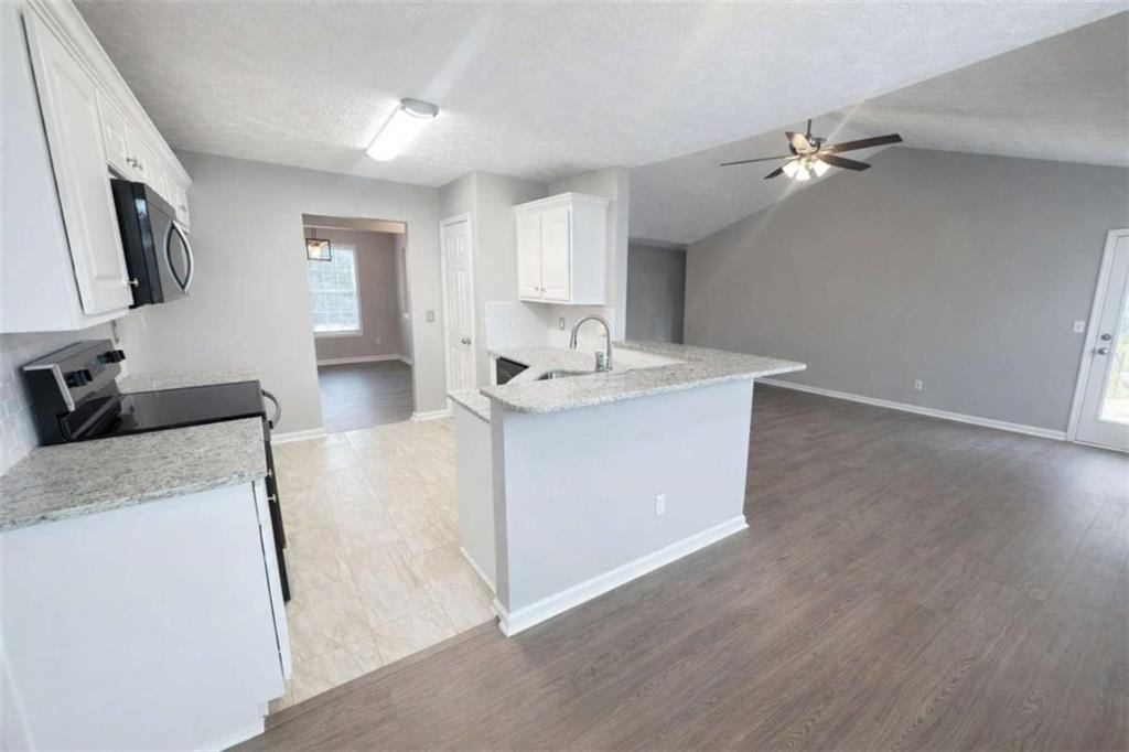 118 Chippewa Run Auburn, GA 30011 - Photo 8 of 26 a room with kitchen island a sink and a stove top oven