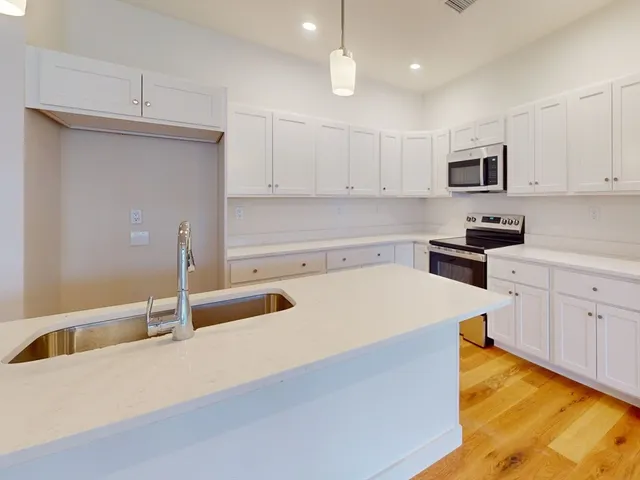 a kitchen that has a sink and a stove in it
