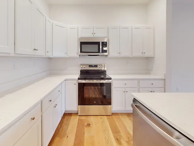 a kitchen with white cabinets and white appliances