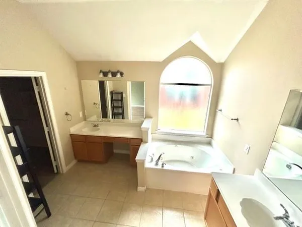 a bathroom with a tub sink and mirror