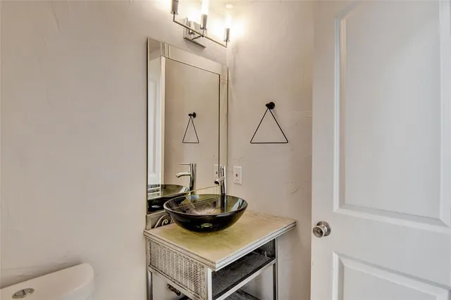 a view of a livingroom with a chandelier fan and windows