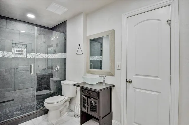 a bathroom with a granite countertop sink toilet and shower