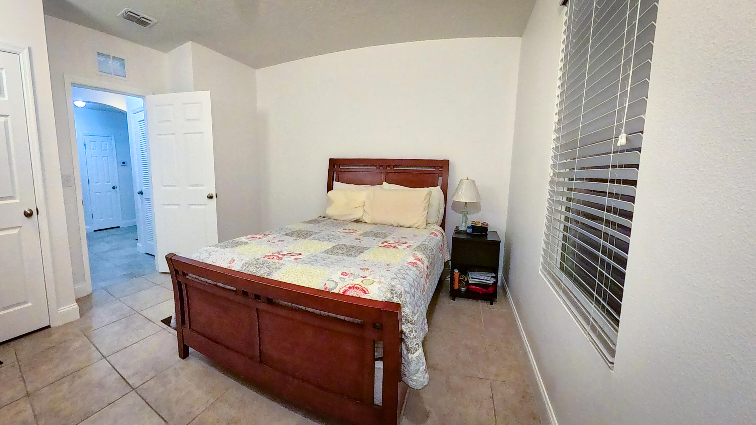 1162 Southwest Coleman Avenue Port St. Lucie, FL 34953 - Photo 11 of 27 a bedroom with a bed and a window