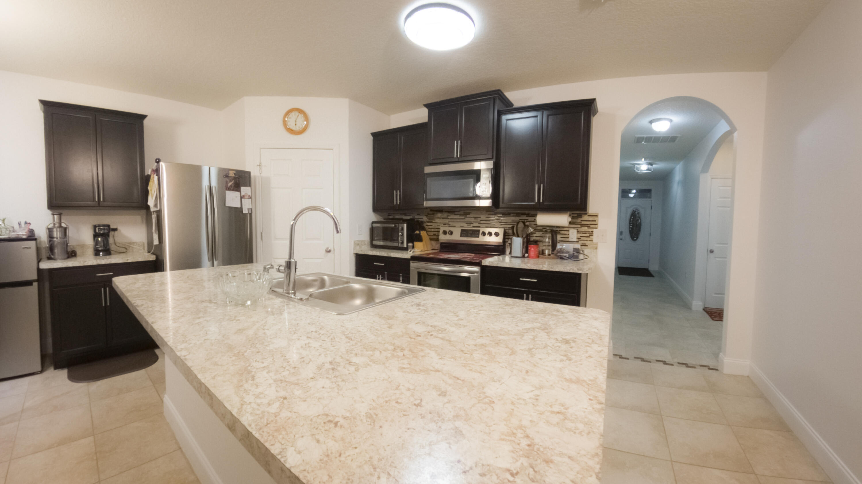 1162 Southwest Coleman Avenue Port St. Lucie, FL 34953 - Photo 15 of 27 a large kitchen with kitchen island a sink stainless steel appliances and cabinets