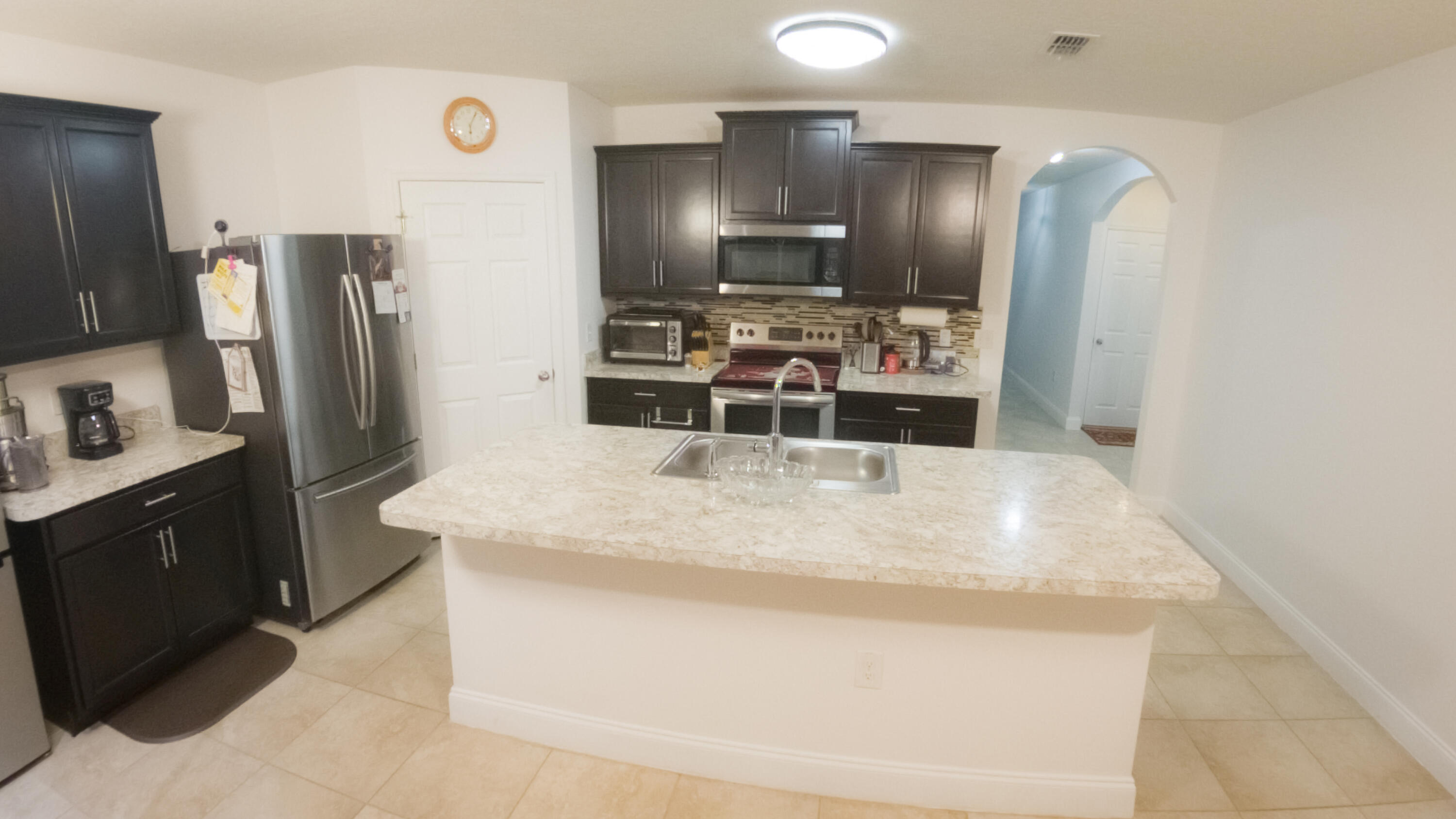 1162 Southwest Coleman Avenue Port St. Lucie, FL 34953 - Photo 16 of 27 a kitchen with stainless steel appliances kitchen island a refrigerator sink and stove