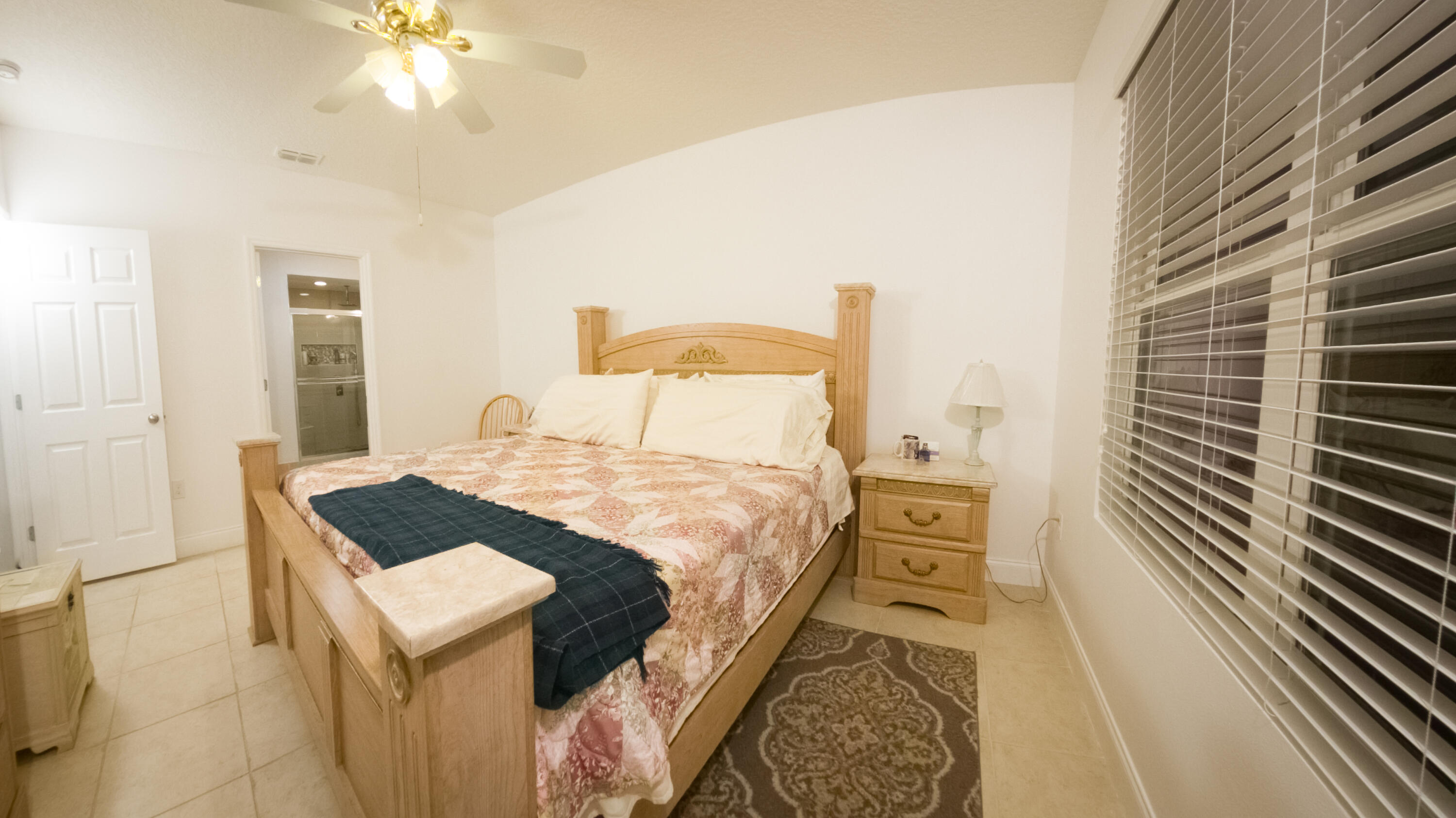 1162 Southwest Coleman Avenue Port St. Lucie, FL 34953 - Photo 20 of 27 a bedroom with a bed and a chandelier