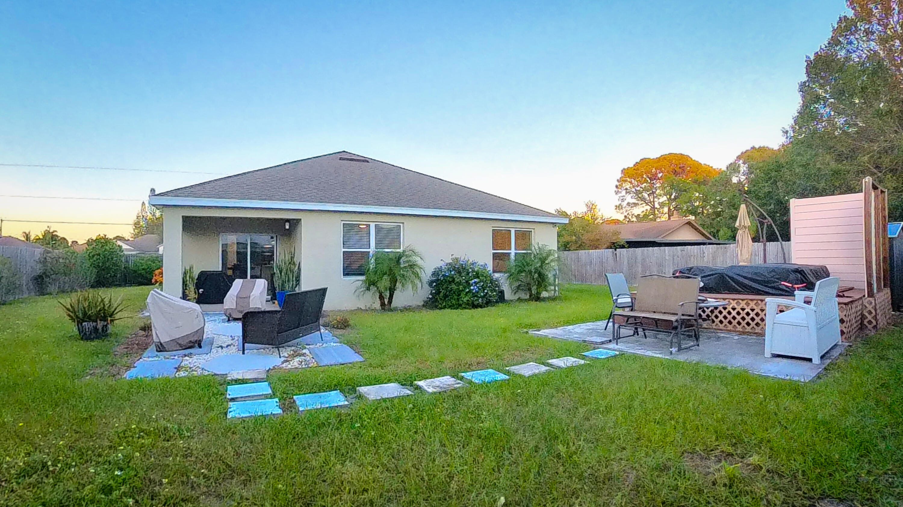 1162 Southwest Coleman Avenue Port St. Lucie, FL 34953 - Photo 25 of 27 a view of a house with backyard sitting area and garden