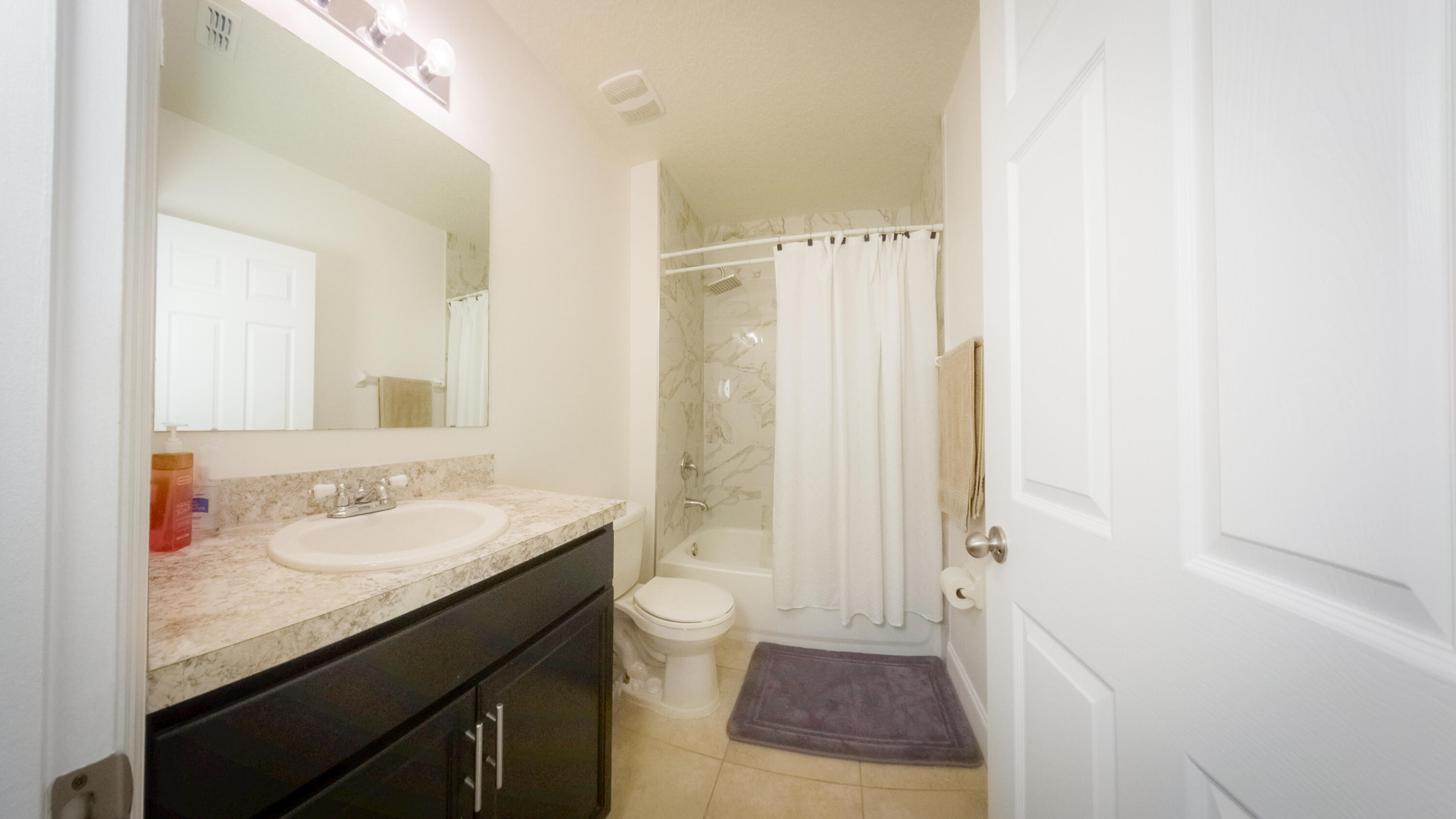1162 Southwest Coleman Avenue Port St. Lucie, FL 34953 - Photo 7 of 27 a bathroom with a granite countertop sink a toilet and shower