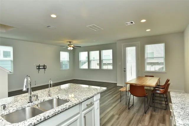 a kitchen with a dining table chairs and sink