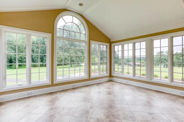 a view of an empty room with a large window and pool