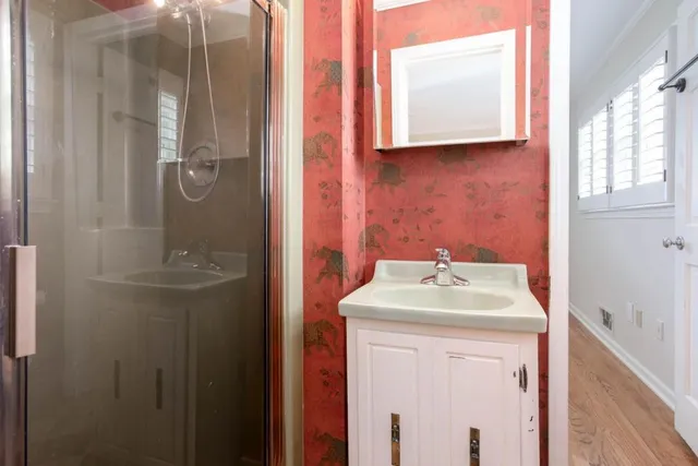 a bathroom with a sink a mirror and shower