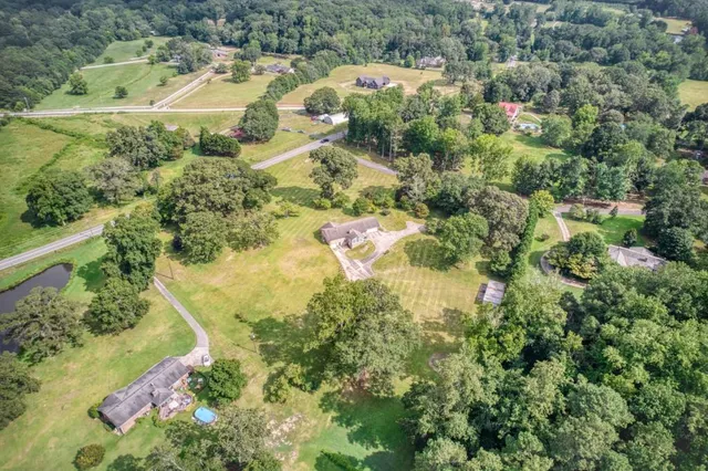 an aerial view of residential houses with outdoor space and trees
