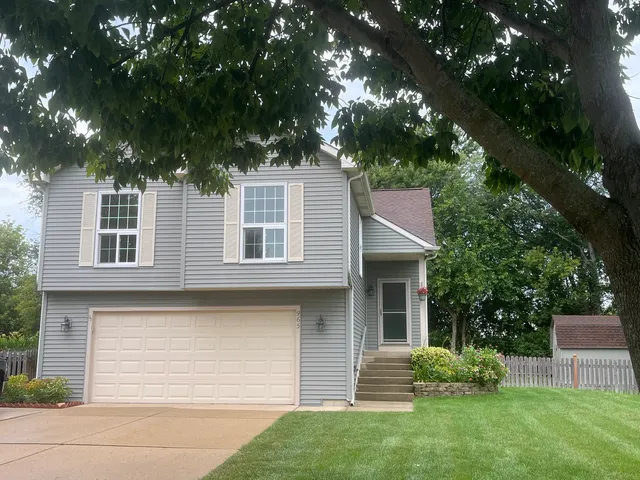 a front view of a house with a garden and yard
