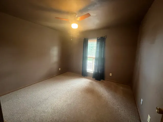 an empty room with windows and closet
