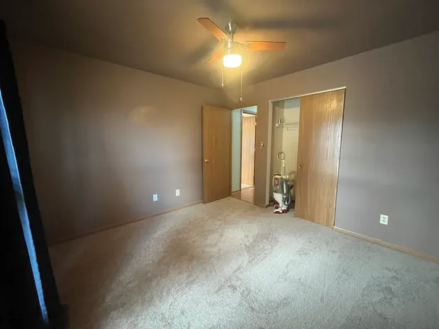 a view of empty room with window and ceiling fan