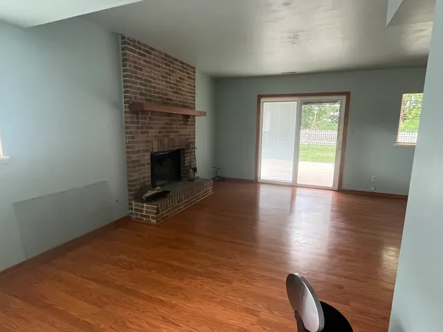 wooden floor in an empty room with a fireplace
