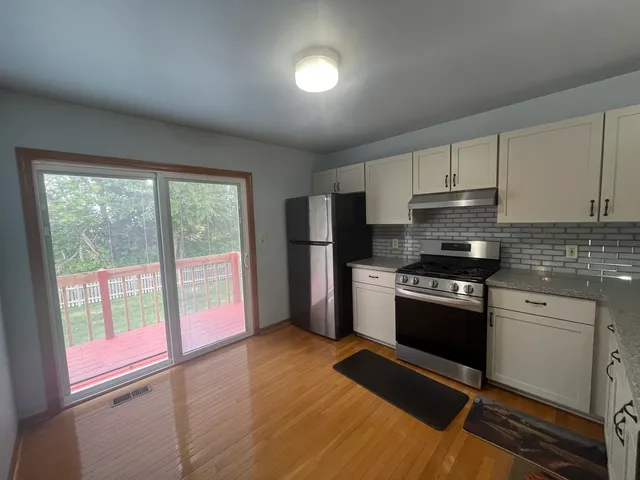 a kitchen with stainless steel appliances granite countertop a stove a sink and a refrigerator