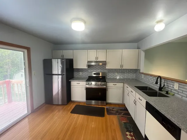 a kitchen with a sink a refrigerator and cabinets