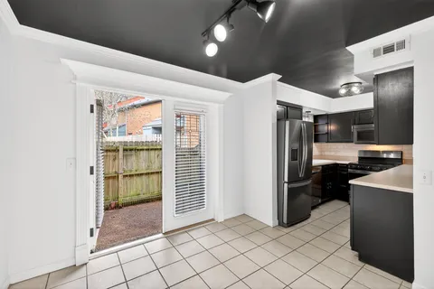 a kitchen with stainless steel appliances kitchen island granite countertop a refrigerator and a sink