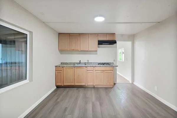 a view of empty room with wooden floor and window