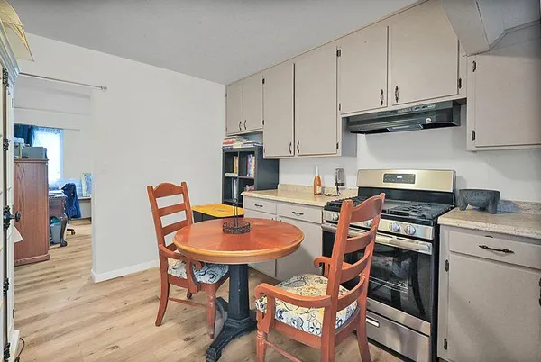 a kitchen with stainless steel appliances granite countertop a stove a sink dishwasher and cabinets with wooden floor