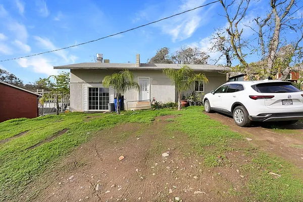 a view of a house with backyard and sitting area