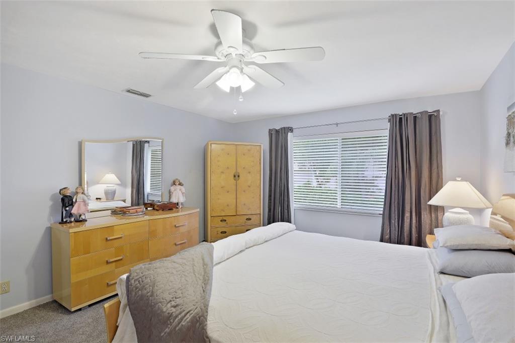 3400 Frosty Way, Unit 4704 Naples, FL 34112 - Photo 11 of 20 a bedroom with a bed and a chandelier