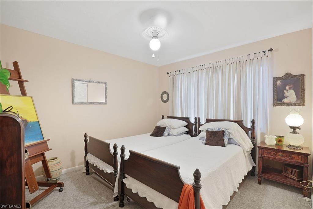 3400 Frosty Way, Unit 4704 Naples, FL 34112 - Photo 13 of 20 a bedroom with a bed and a chandelier