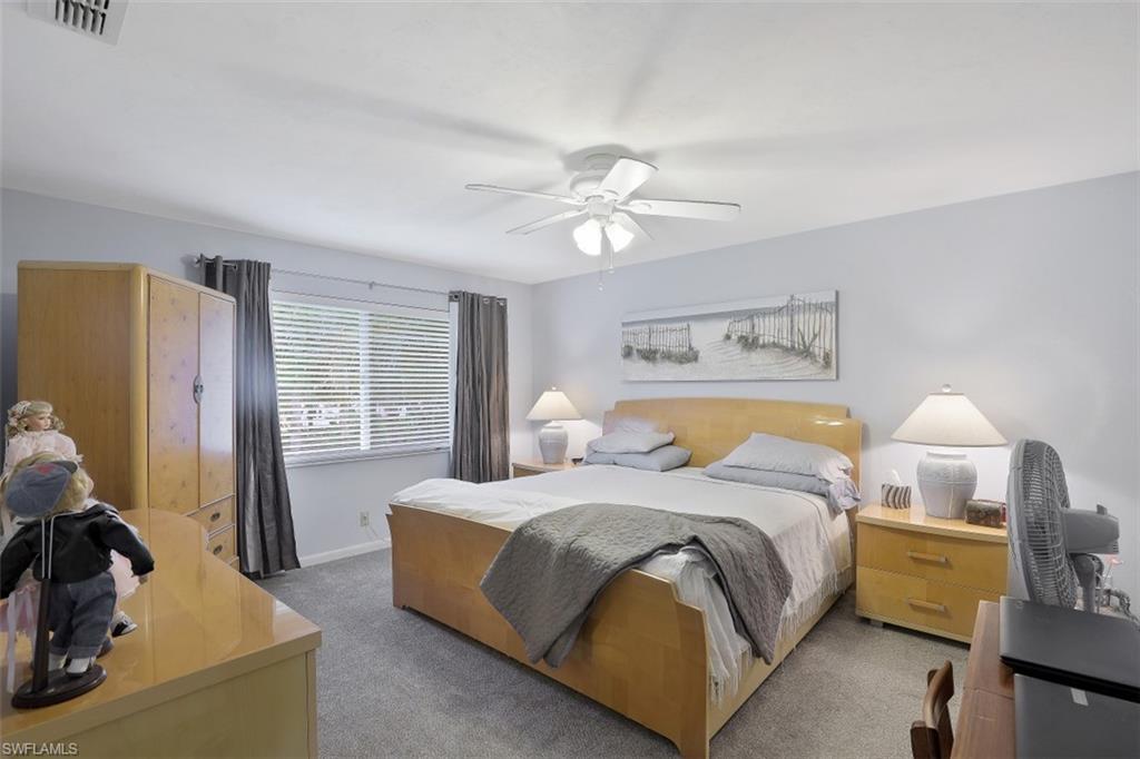 3400 Frosty Way, Unit 4704 Naples, FL 34112 - Photo 10 of 20 a spacious bedroom with a bed and a chandelier