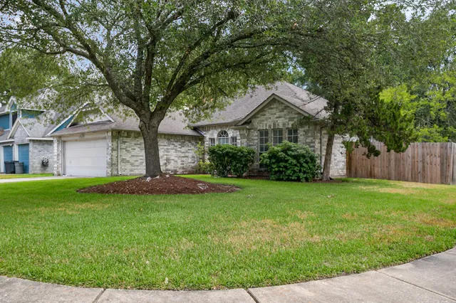 a front view of a house with a garden and yard