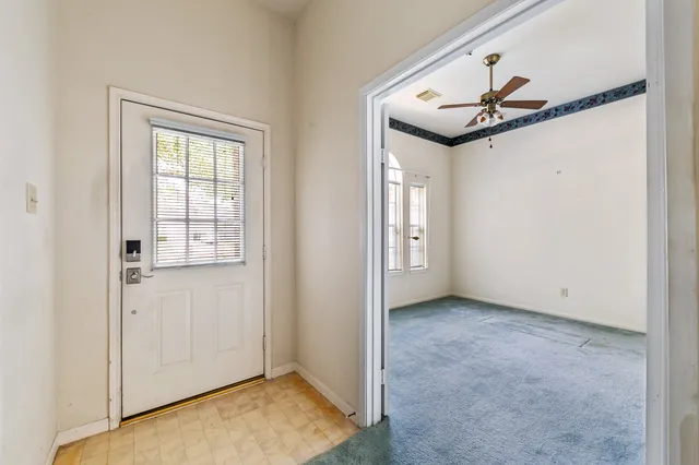 an empty room with windows and fan