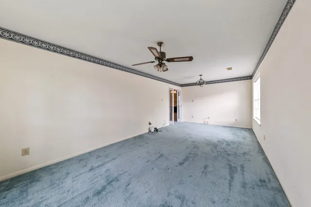 a view of a room with a ceiling fan and window