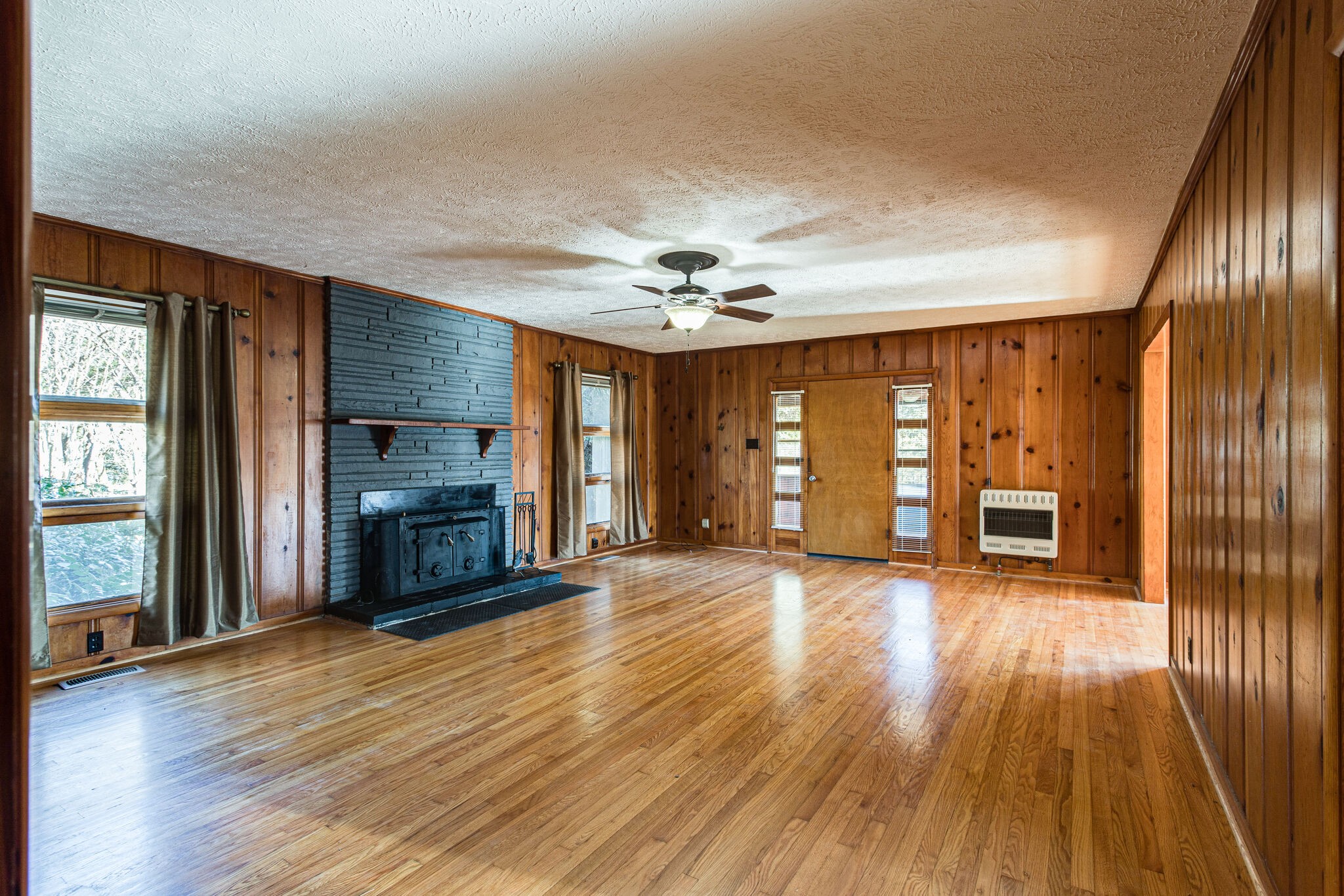 404 Monroe Floyd Road Decherd, TN 37324 - Photo 8 of 44 an empty room with wooden floor fireplace and windows
